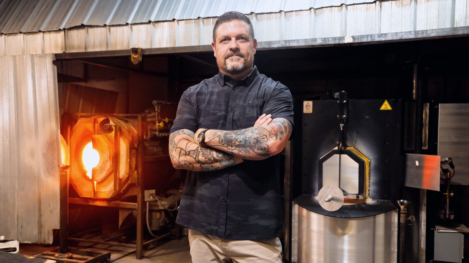 Steve Baumgartner standing in front of a glowing furnace